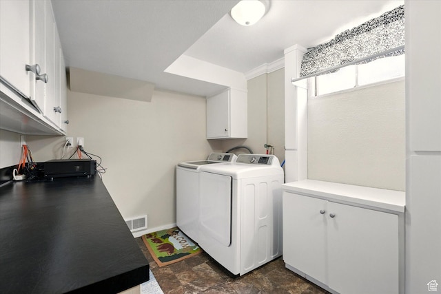 laundry room with separate washer and dryer, cabinet space, and dark stone finish floors