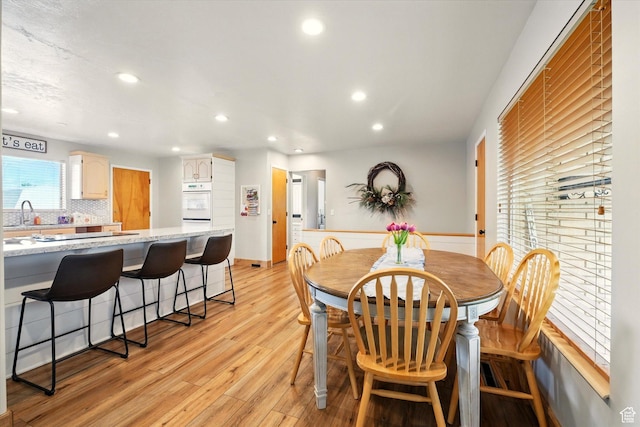 dining room with light wood-type flooring and recessed lighting