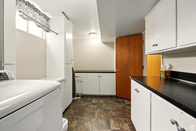laundry room with washer / clothes dryer, cabinet space, and stone finish floors