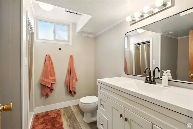 bathroom featuring ornamental molding, wood finished floors, toilet, vanity, and curtained shower