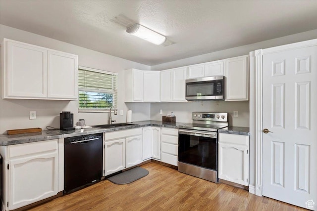 2115 N 600 W, West Bountiful, UT 84087 - kitchen featuring appliances with stainless steel finishes, a sink, white cabinets, dark countertops, and light wood-type flooring