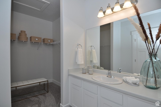 bathroom with vanity and a walk in closet