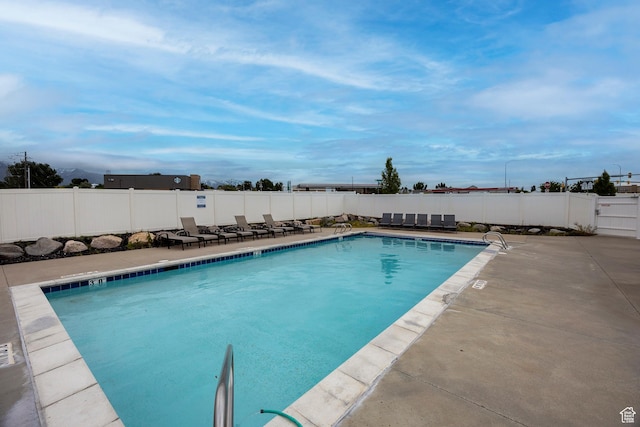community pool featuring a patio and a fenced backyard