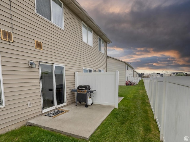back of property at dusk with a patio area