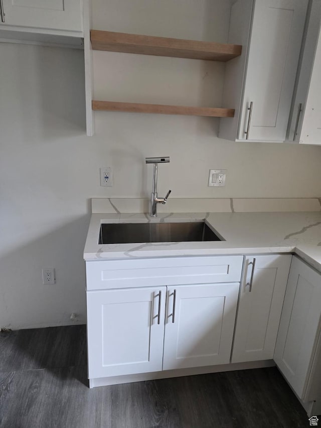 kitchen featuring dark wood-style floors, a sink, open shelves, and white cabinetry