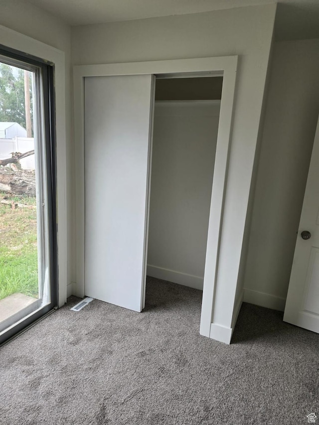 unfurnished bedroom with carpet flooring and a closet