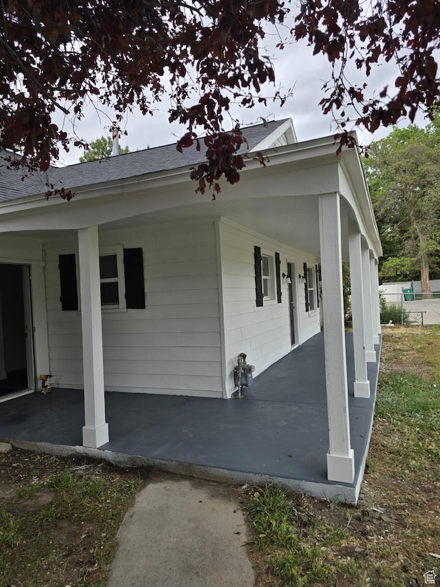 view of home's exterior with covered porch and roof with shingles