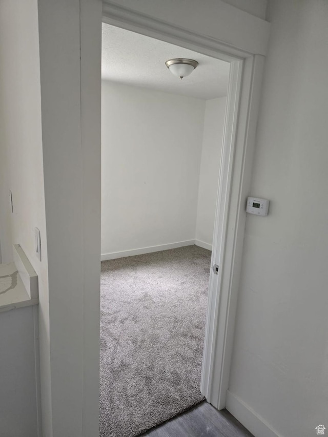carpeted empty room featuring baseboards