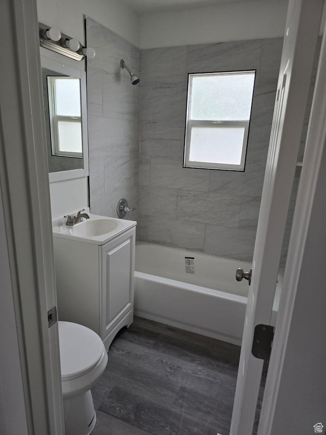 bathroom featuring vanity, toilet, shower / washtub combination, and wood finished floors