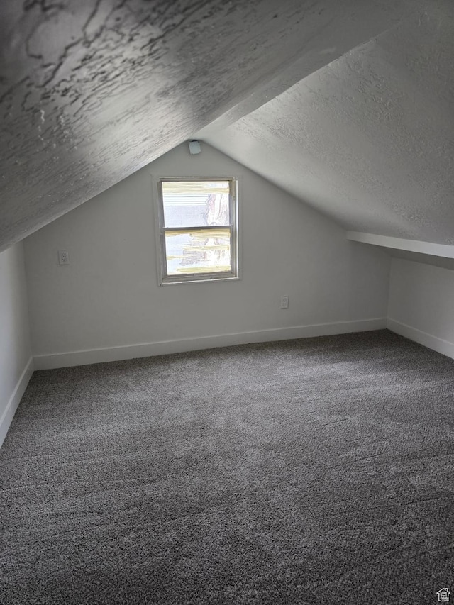 bonus room with a textured ceiling, vaulted ceiling, baseboards, and carpet