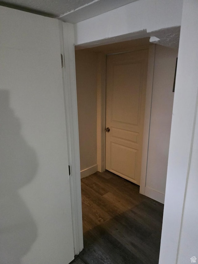 corridor featuring wood finished floors and baseboards