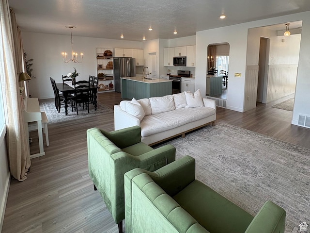 3452 W Pond Dr S, Lehi, UT 84043 - living area featuring a chandelier, wood finished floors, arched walkways, recessed lighting, and baseboards