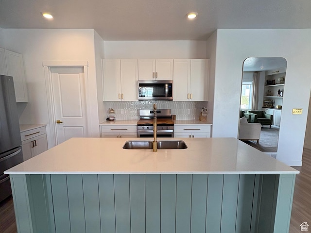 3452 W Pond Dr S, Lehi, UT 84043 - kitchen with stainless steel appliances, a sink, arched walkways, white cabinetry, and tasteful backsplash