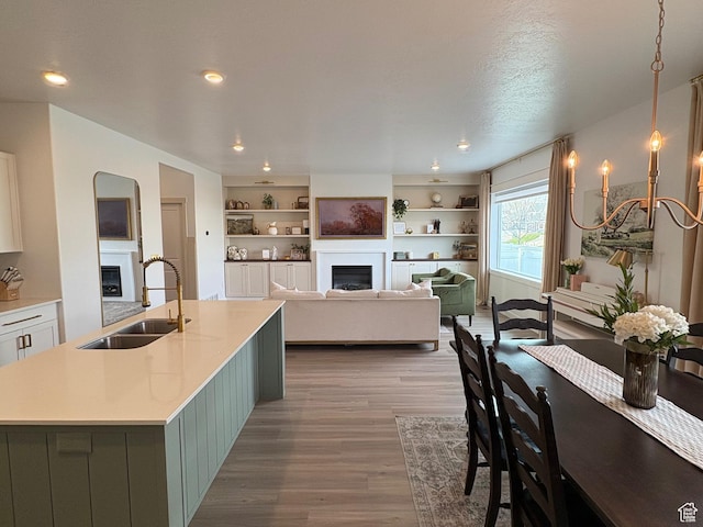 3452 W Pond Dr S, Lehi, UT 84043 - kitchen with a fireplace, a sink, wood finished floors, light countertops, and recessed lighting