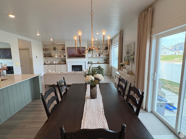 3452 W Pond Dr S, Lehi, UT 84043 - dining space with a fireplace, wood finished floors, a chandelier, and recessed lighting