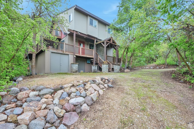 back of property with a deck and stairway