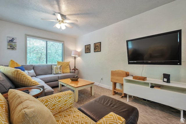 living area with ceiling fan, a textured ceiling, baseboards, and carpet