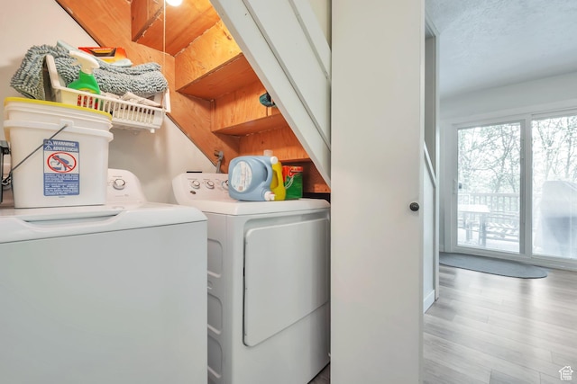 laundry room with independent washer and dryer and light wood-type flooring
