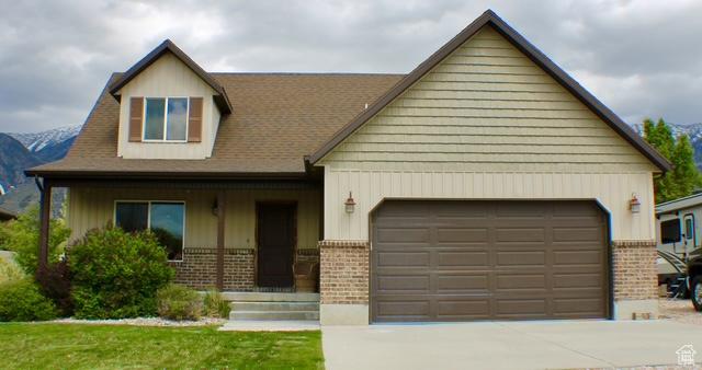 view of front of property featuring brick siding, an attached garage, and concrete driveway