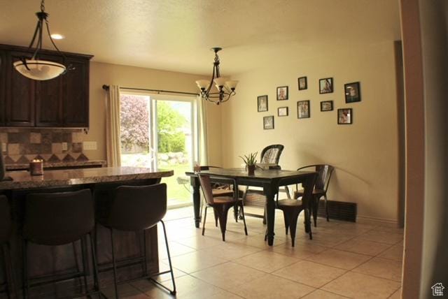 dining space with a chandelier, light tile patterned flooring, and recessed lighting