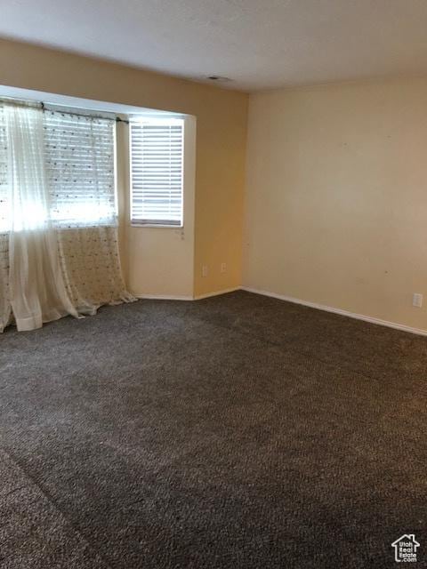 3923 W Rockwood Way Unit G, West Valley City, UT 84120 - spare room featuring dark colored carpet and baseboards