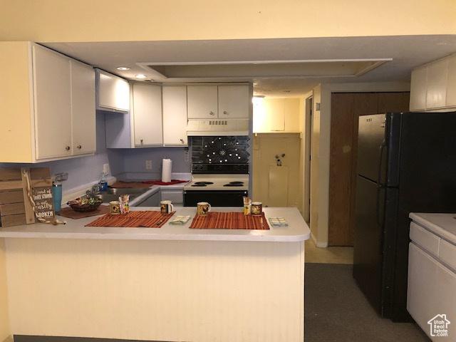 3923 W Rockwood Way Unit G, West Valley City, UT 84120 - kitchen featuring a peninsula, electric range, freestanding refrigerator, light countertops, and white cabinetry
