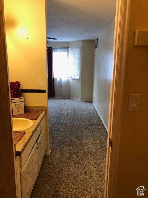 3923 W Rockwood Way Unit G, West Valley City, UT 84120 - hall featuring dark carpet, baseboards, and a sink