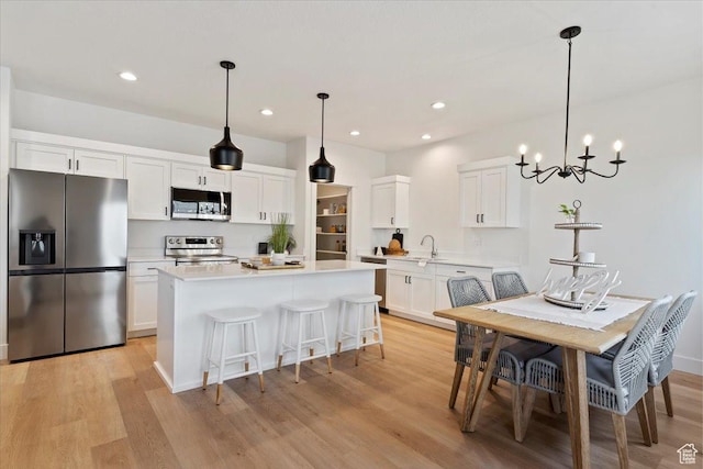 2085 W 1575th Ct S Unit 126, West Haven, UT 84401 - kitchen with appliances with stainless steel finishes, light wood finished floors, light countertops, white cabinets, and a center island
