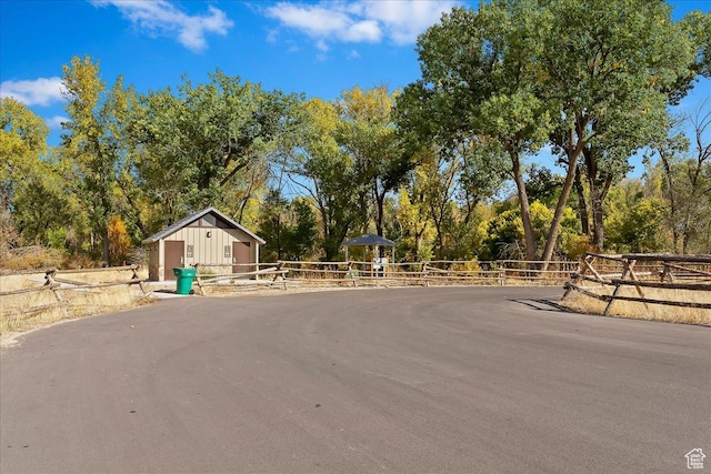 2085 W 1575th Ct S Unit 126, West Haven, UT 84401 - view of front facade featuring an outdoor structure, fence, and view of wooded area