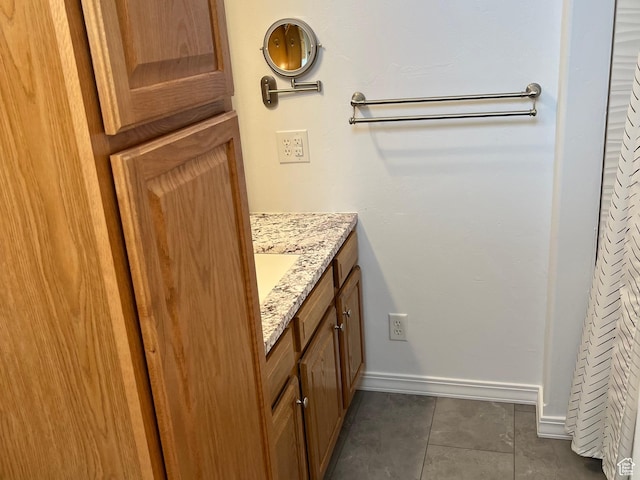 bathroom with baseboards, tile patterned floors, and vanity