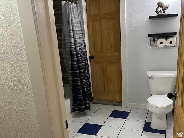 full bath featuring marble finish flooring, toilet, a textured wall, baseboards, and shower / tub combo with curtain