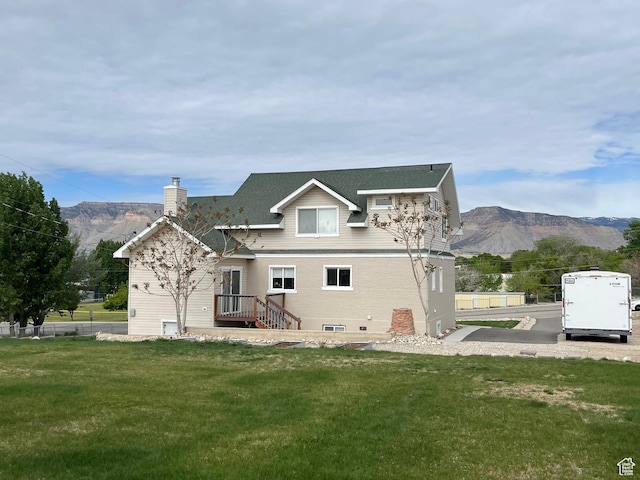 rear view of house featuring a chimney and a mountain view