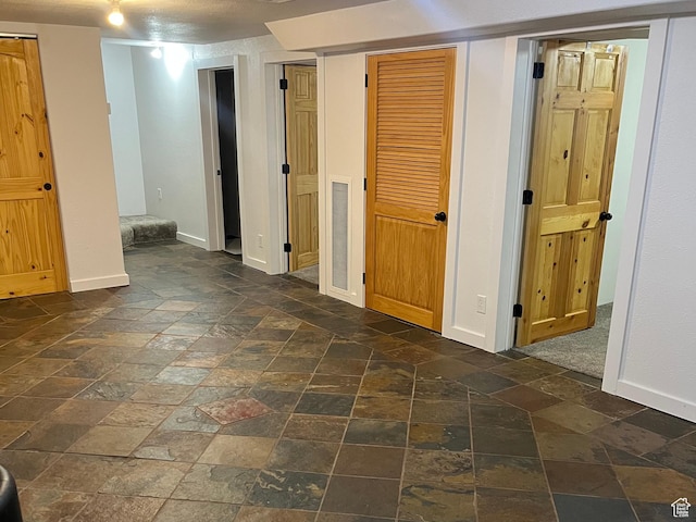 finished below grade area with stone tile floors and baseboards