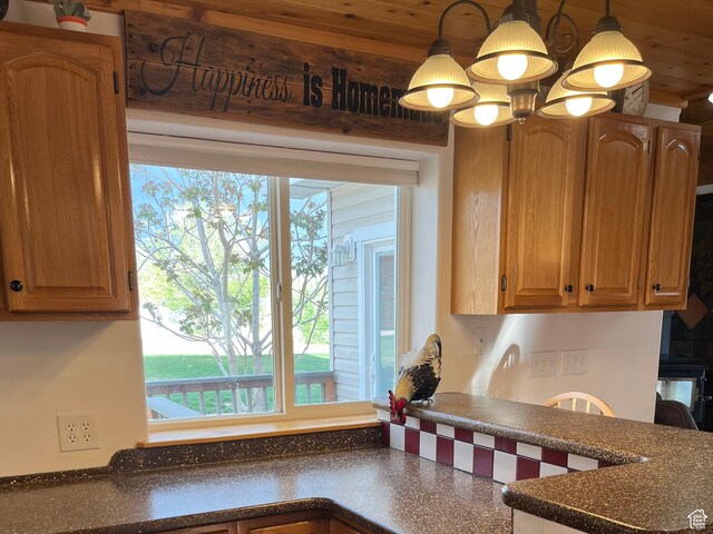 kitchen featuring dark countertops, healthy amount of natural light, pendant lighting, and wooden ceiling