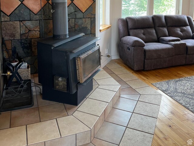 living area with a wood stove and wood finished floors