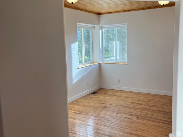 unfurnished room featuring wooden ceiling, light wood finished floors, and baseboards
