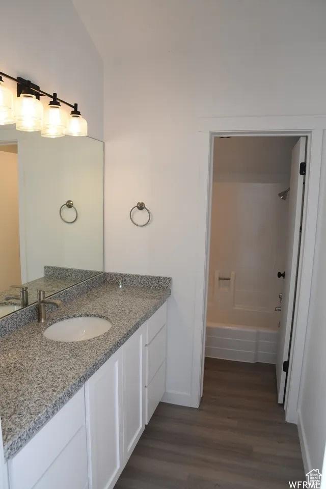 227 S W Ln, Provo, UT 84601 - full bathroom with baseboards, wood finished floors, vanity, and shower / washtub combination