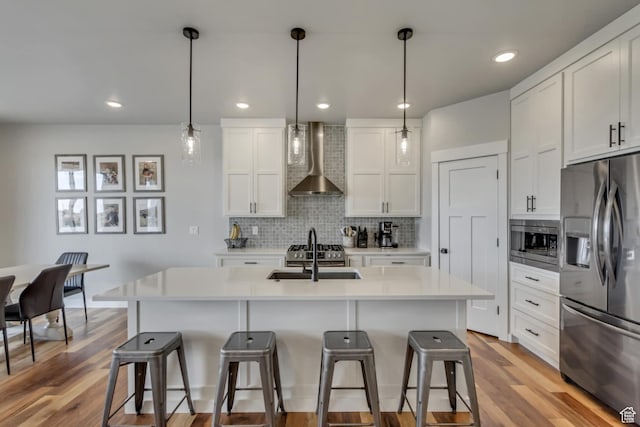 3537 S 5050 W, West Haven, UT 84401 - kitchen with appliances with stainless steel finishes, wall chimney exhaust hood, a sink, a breakfast bar, and tasteful backsplash