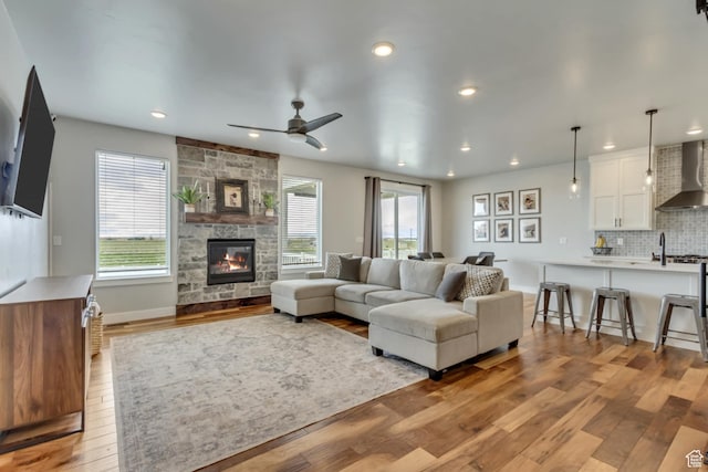 3537 S 5050 W, West Haven, UT 84401 - living room with light wood finished floors, a stone fireplace, ceiling fan, recessed lighting, and baseboards