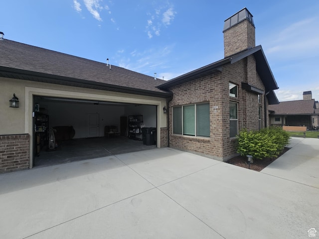1704 W 300 S Unit Ud/L24, Mapleton, UT 84664 - view of home's exterior with brick siding, a chimney, concrete driveway, and roof with shingles