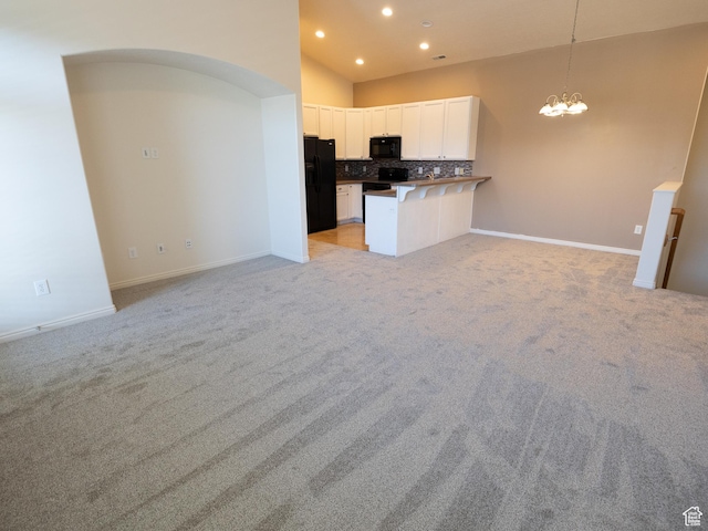6324 S Traveler Ln W, West Jordan, UT 84081 - kitchen featuring black appliances, open floor plan, a chandelier, tasteful backsplash, and white cabinetry