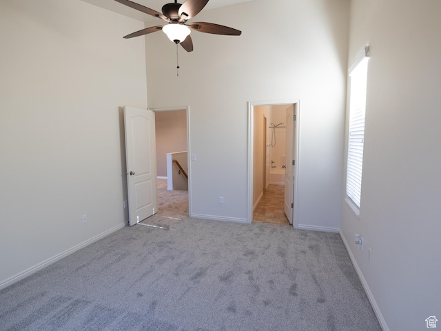 6324 S Traveler Ln W, West Jordan, UT 84081 - unfurnished bedroom with a towering ceiling, light colored carpet, baseboards, multiple windows, and connected bathroom