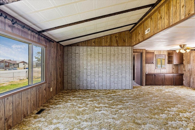 830 E Main St, Grantsville, UT 84029 - unfurnished living room with wood walls, vaulted ceiling, carpet, and a ceiling fan