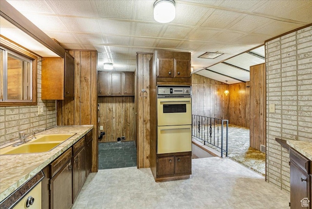830 E Main St, Grantsville, UT 84029 - kitchen with a sink, wood walls, light countertops, double oven, and light floors