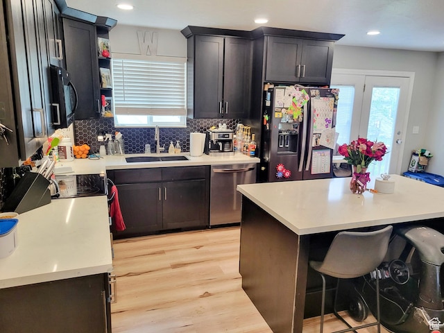 kitchen with appliances with stainless steel finishes, a sink, light wood-style floors, healthy amount of natural light, and recessed lighting