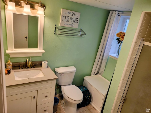 full bath featuring toilet, a shower, vanity, and tile patterned flooring