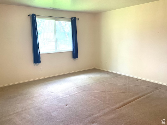 empty room featuring carpet floors and baseboards