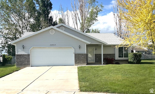 ranch-style home with brick siding, an attached garage, a front lawn, concrete driveway, and roof with shingles