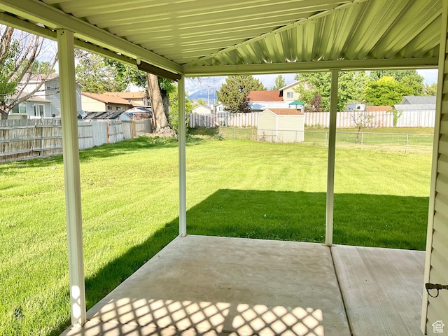 view of yard featuring a patio area, a storage unit, and a residential view