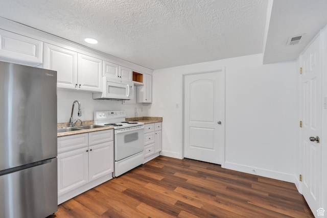 kitchen featuring white appliances, a sink, dark wood finished floors, baseboards, and a textured ceiling
